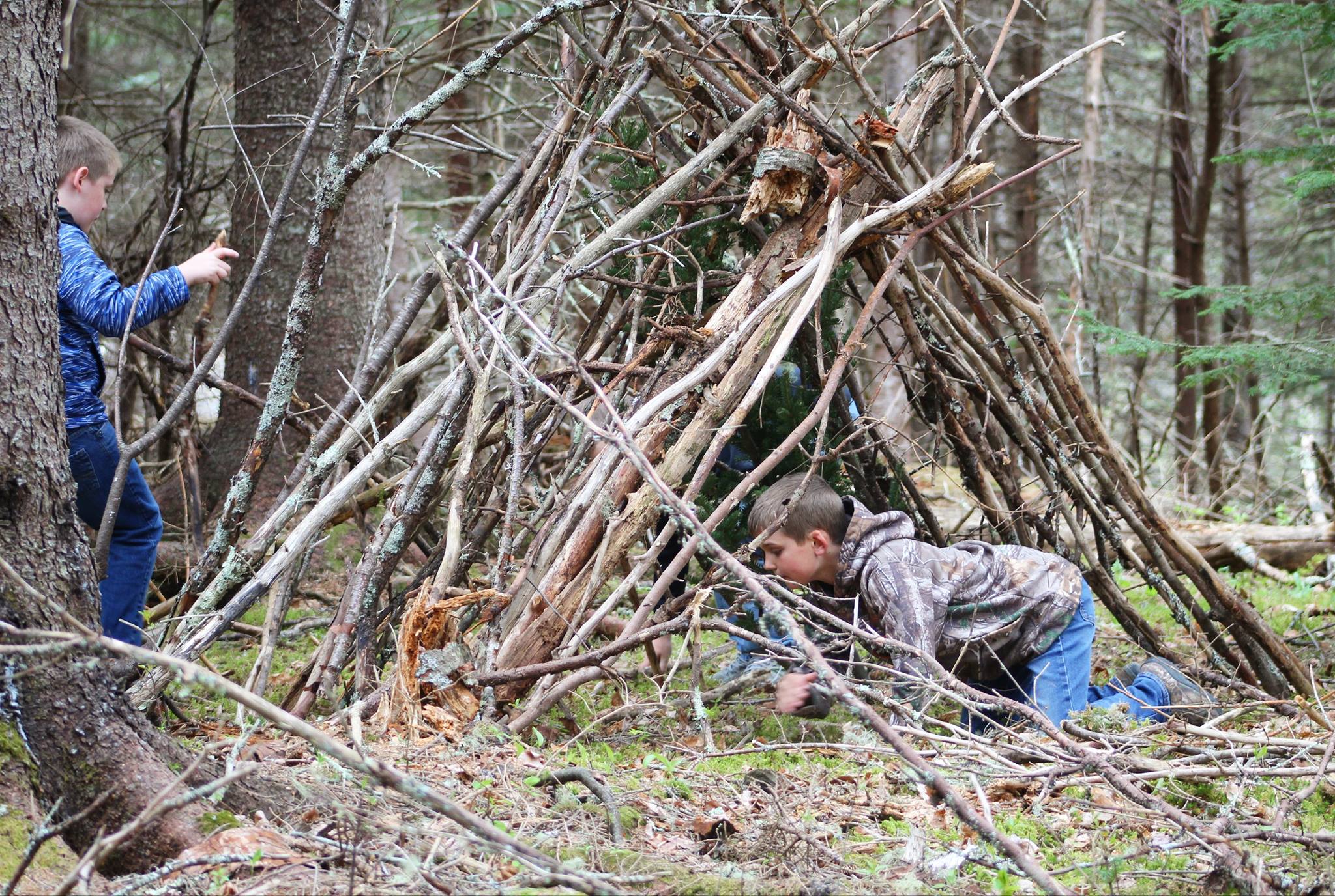 Two children work in the woods behind Milbridge Elementary School in Milbridge, Maine to build a shelter and outdoor classroom. Milbridge Elementary School partners with the organization Transforming Rural Experiences in Education (TREE) to provide trauma-informed outdoor learning experiences to students in rural Maine. Photo Credit: Donald Parker