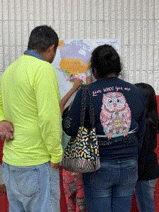 An immigrant family viewing a map of their countries in North and Central America