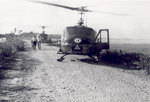 Helicopters on road next to field