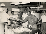 Sonny Montgomery greets an African-American soldier in a kitchen
