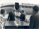 Sonny Montgomery talks with 2 men in front of United Nations plane