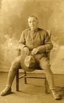 Male Soldier Seated in a Chair [postcard photo]