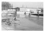 Children riding bicycles in flooded parking lot - Tombigbee River Flood 1974