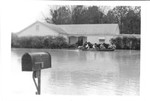 Rescue workers in boat passing flooded house - Tombigbee River Flood 1974.