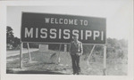 Man Standing in Front of a Welcome to Mississippi Road sign, December 1946