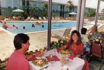 People Seated In a Hotel Restaurant Beside a Pool