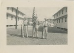 Three Uniformed Airmen Standing at Attention with Guns and a Flag