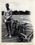 A Man Standing Beside a Bicycle on a Pier