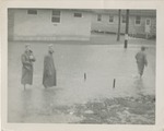 Men in Raincoats Wading in a Flooded Street at the Barracks, Keesler Field (Keesler Air Force Base)