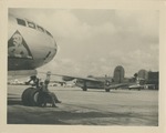 United States Air Force Airman Seated Beside an Airplane's Landing Gear