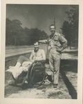 United States Air Force Airman in a Wheelchair with a Cast on His Leg and Another Airman Standing Beside Him