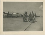 Airmen Walking Across the Airfield, An Airplane Behind Them
