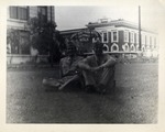 Two Airmen in Uniform Sitting on the Ground in front of the Great Southern Hotel