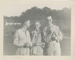 Three Airmen in Uniform Standing in Front of a Chain Link Fence