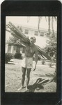 Man in Shorts Carrying Boat Paddles on His Shoulder