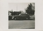 A Mid-Twentieth Century Car Parked in Front of a House