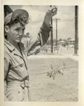 A Man in Coveralls Holding a Toy Airplane by a String