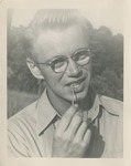 Headshot of a Light-haired Man in Eyeglasses with a Toothpick