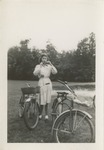 Woman Standing in a Field with Two Bicycles