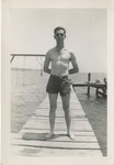 Man Wearing Shorts and Sunglasses Stands on a Pier