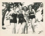 Four Women in Swim Suits Posing on a Beach