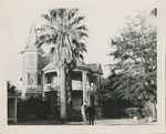 Two Uniformed United States Air Force Airmen Stand in Front of a Large House