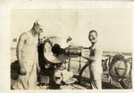 Two Sailors Standing Beside a Five Inch Gun on a Ship
