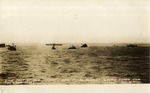 Five Smaller Boats with United States Flags on the Water In Front of a Large Ship