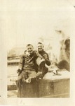 Two Sailors in Dark Uniforms Smiling While Seated in the Boston Navy Yard