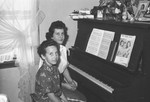 Two girls at piano by Howard Langfitt