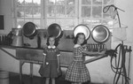 Two girls in milk barn by Howard Langfitt