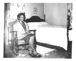 Woman Sitting Next to Bed