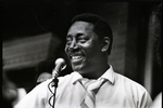 Charles Evers Smiling Behind a Microphone
