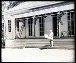 Man Standing on Front Steps to a White Building