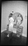 Woman in Dress Looking in Mirror by Fred A. Blocker