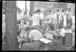 Students Sitting Around Picnic Tables by Fred A. Blocker