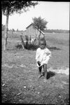 Small Child Standing in Grass by Fred A. Blocker