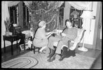 Couple Seated in front of Christmas Tree by Fred A. Blocker