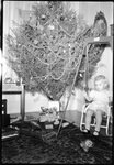 Child Playing Beside Christmas Tree by Fred A. Blocker