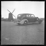 Car Parked in front of a Windmill by Fred A. Blocker