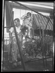 Man Helping Girl on High Swing by Fred A. Blocker