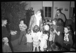 Children with Santa in front of Christmas Tree by Fred A. Blocker