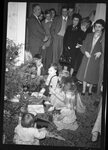 People Watching Children Unwrap Gifts by Fred A. Blocker