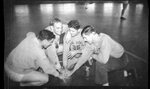 Players Huddle with Hands on Basketball by Fred A. Blocker
