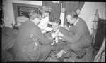 Man Sitting on Floor Being Helped by Friends by Fred A. Blocker