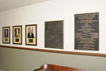 Various photographs and plaques hanging on wall inside building